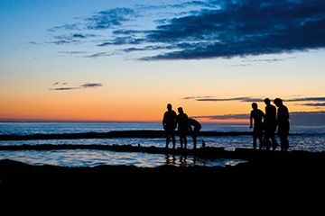 Students on West Sands beach at sunset