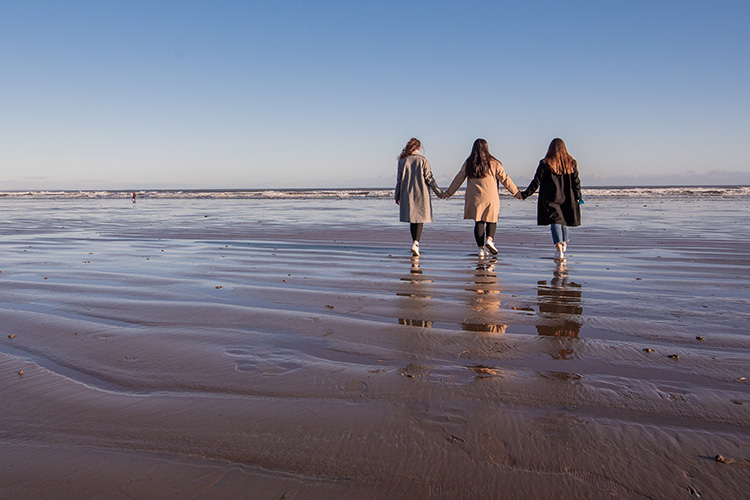 three students on beach