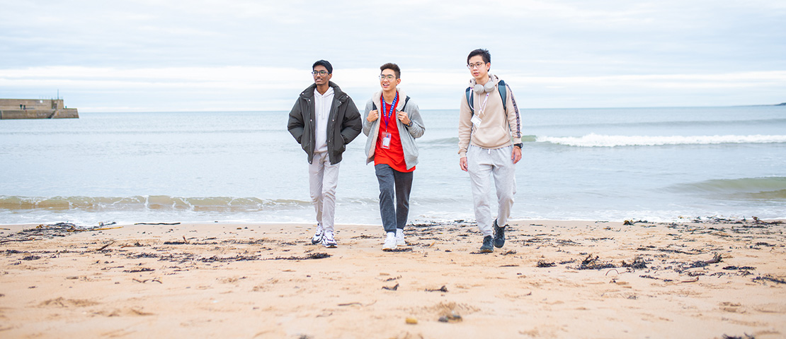 three students on beach