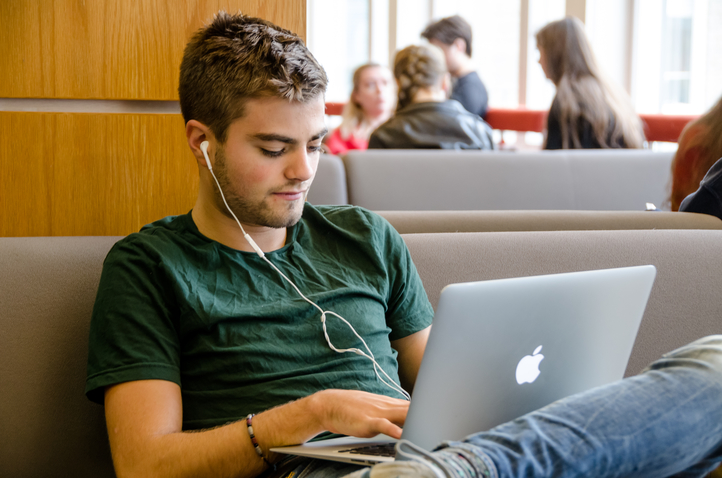 Male postgraduate sat using his laptop