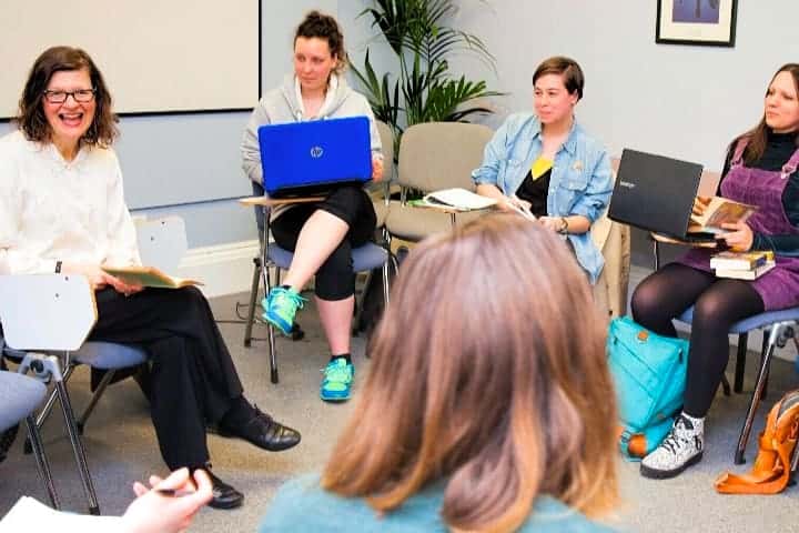 A group of students sits in a discussion circle