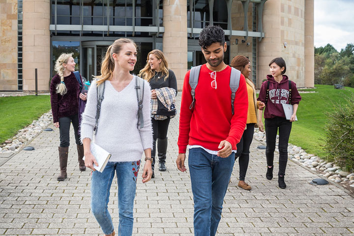Group of students walking in front of the Gateway building in the North Haugh