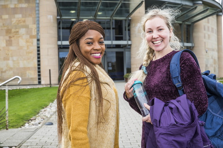 Students similing in front of the Gateway building