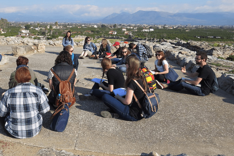people wearing rucksacks sitting on the ground