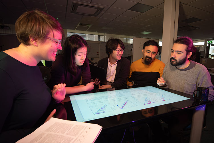 Postgraduate research students looking at a screen