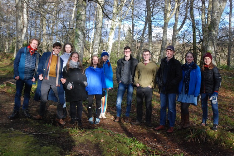 Students standing in a woodland in March.