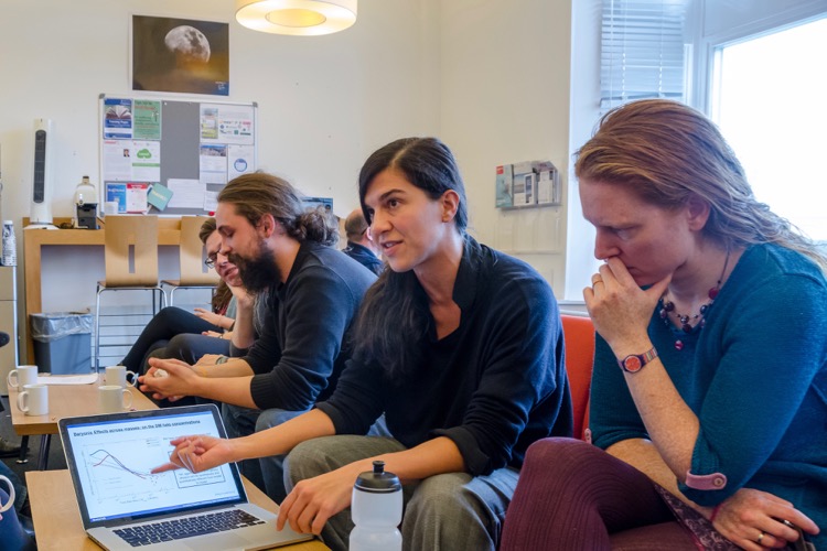 Several scientists discussing a topic over coffee.