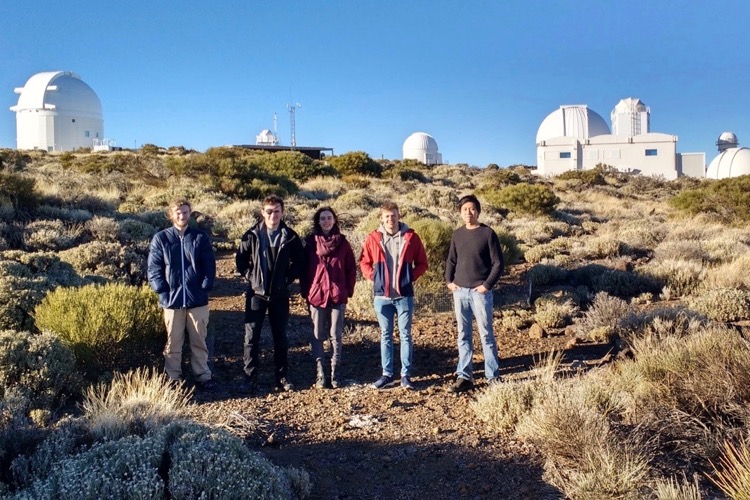 Students standing in on a mountain side with Teide Observatory on the top.