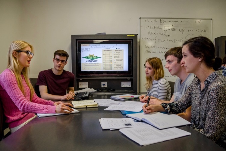 Physics undergraduate students discussing a lecture.