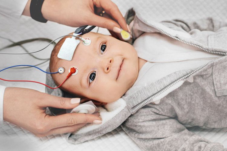Smiling baby with EEG equipment