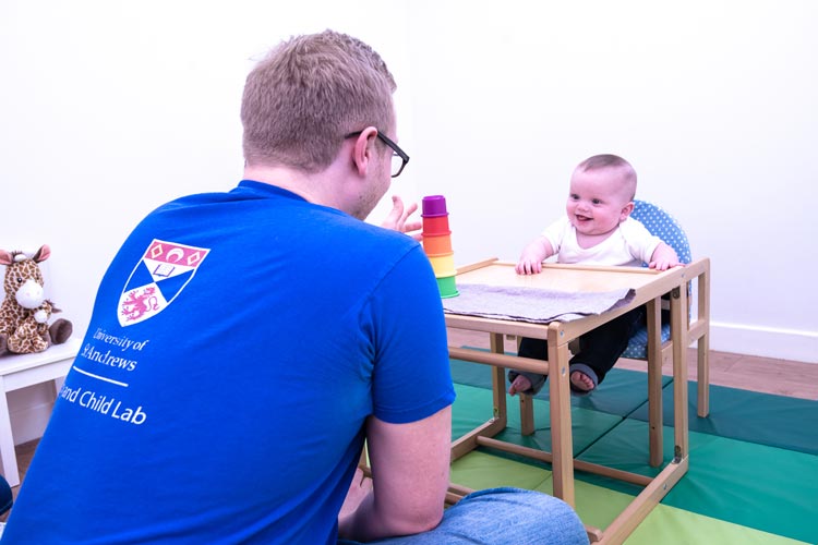 Research student working in the ABC Lab with baby.