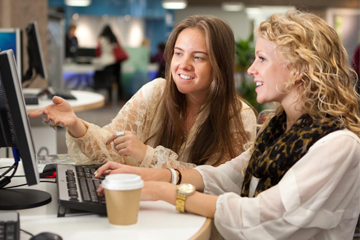 A couple of students gathered around a computer screen.