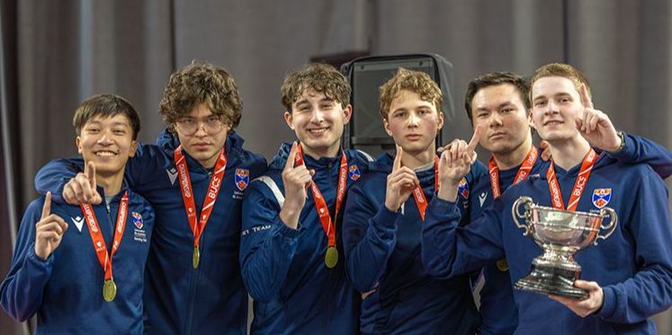 The University of St Andrews Mixed Fencing Team pose for a photo - the six male students are wearing branded kit and medals and holding up one finger The University of St Andrews Mixed Fencing Team pose for a photo - the six male students are wearing branded kit and medals and holding up one finger