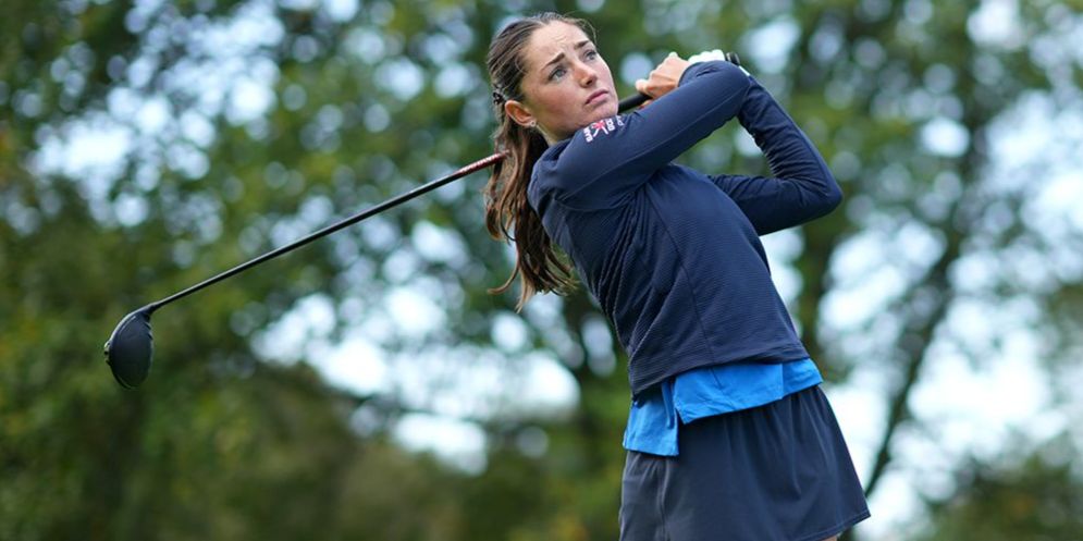 Caitlin Maurice in Saints Golf clothing mid-swing with her golf club in hand 