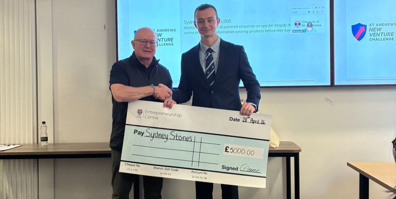 Sydney Stones shakes hands with Derek Watson while holding a large £5000 cheque