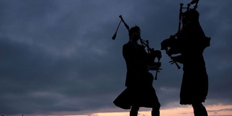 silhouette of two pipers over a sunset sky silhouette of two pipers over a sunset sky