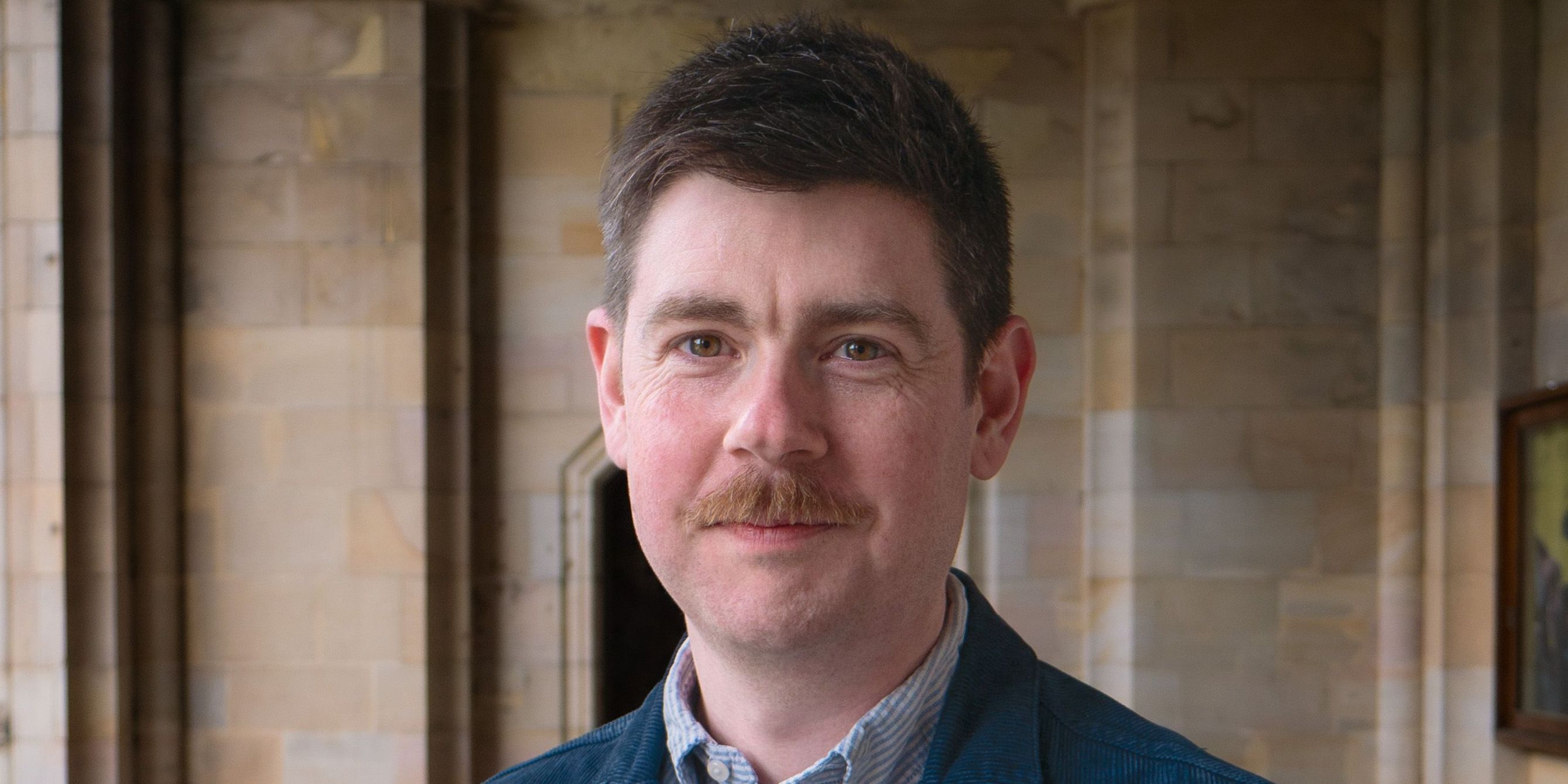 Headshot of Dr Niall Sreenan in the cloisters, St Salvator's Quad Headshot of Dr Niall Sreenan in the cloisters, St Salvator's Quad