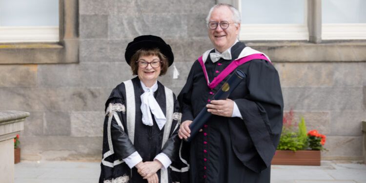 Professor Dr Michael Hoch and Professor Dame Sally Mapstone pose for a photo on graduation day. Dr Hoch holds a degree in his hands Professor Dr Michael Hoch and Professor Dame Sally Mapstone pose for a photo on graduation day. Dr Hoch holds a degree in his hands