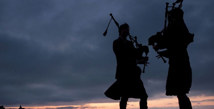 The silhouettes of two pipers on the pier. The silhouettes of two pipers on the pier.