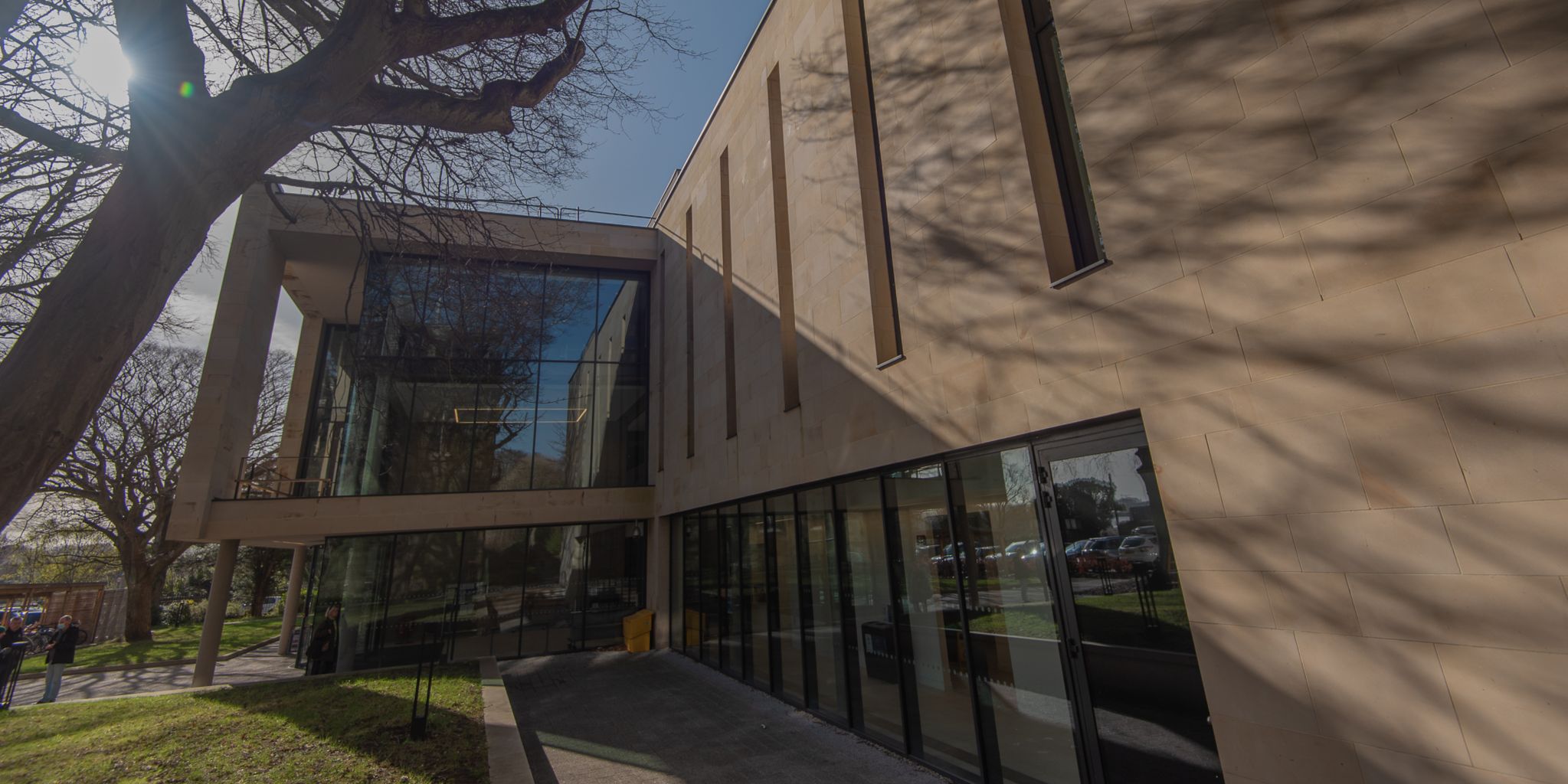 Exterior image of the Laidlaw Music Centre. Shadows from the surrounding trees are cast on to the side of the building Exterior image of the Laidlaw Music Centre. Shadows from the surrounding trees are cast on to the side of the building